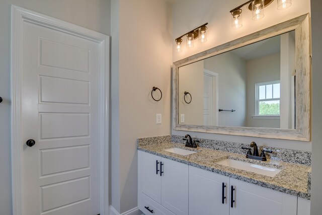 bathroom featuring a sink and double vanity