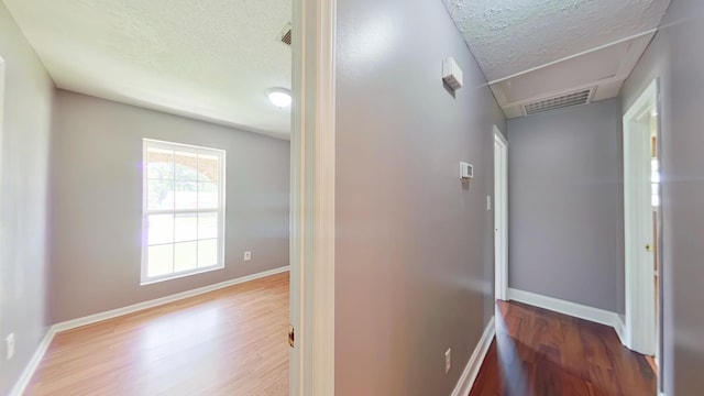 3611 Sturnidae Dr, Augusta, GA 30906 - hallway with a textured ceiling, wood finished floors, and attic access