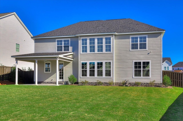 rear view of house featuring a yard