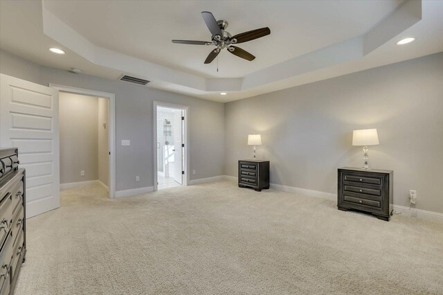 bedroom with a tray ceiling, ceiling fan, and light colored carpet