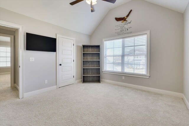 unfurnished bedroom with multiple windows, light colored carpet, ceiling fan, and lofted ceiling