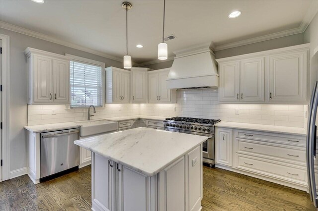 kitchen featuring sink, custom range hood, a kitchen island, white cabinetry, and stainless steel appliances