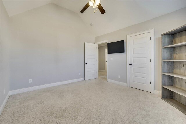 unfurnished bedroom featuring ceiling fan, a closet, light carpet, and vaulted ceiling