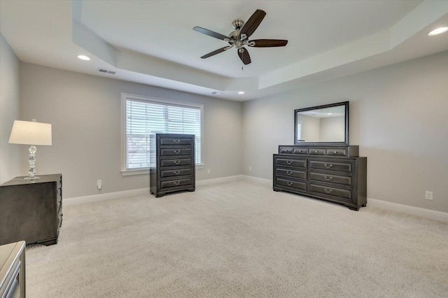 sitting room with ceiling fan, a raised ceiling, and light colored carpet