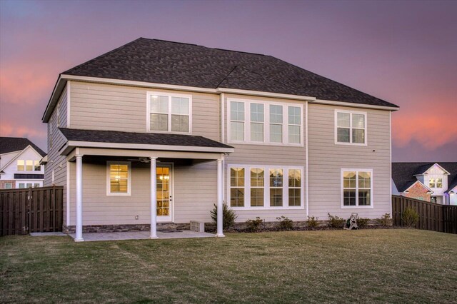 back house at dusk with a yard