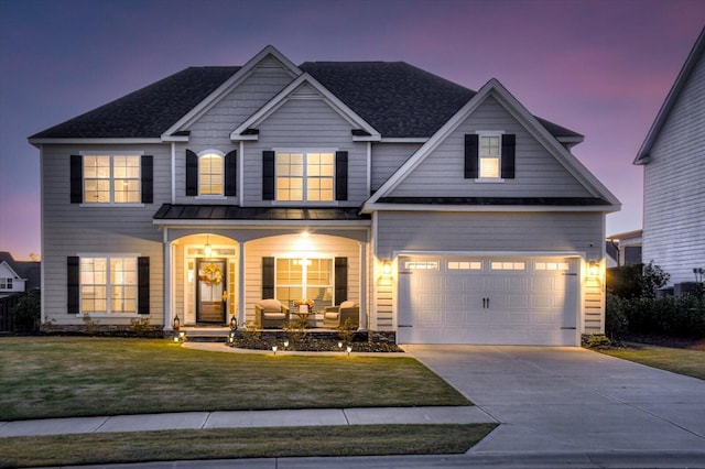 craftsman-style house with a yard, covered porch, and a garage