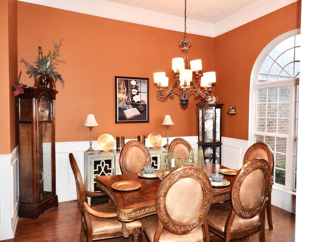 dining space with dark hardwood / wood-style floors, crown molding, and a notable chandelier