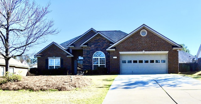 view of front facade featuring stone siding, brick siding, driveway, and an attached garage