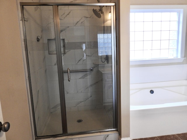 bathroom featuring separate shower and tub