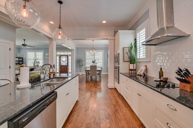 2084 Egret Cir, Evans, GA 30809 - kitchen with wall chimney range hood, stainless steel appliances, a sink, wood finished floors, and white cabinetry
