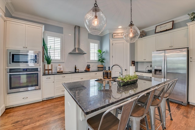 2084 Egret Cir, Evans, GA 30809 - kitchen with appliances with stainless steel finishes, wall chimney exhaust hood, ornamental molding, backsplash, and a kitchen breakfast bar