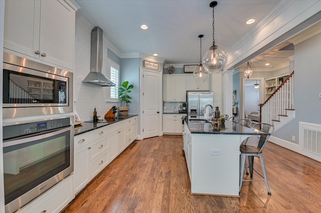 2084 Egret Cir, Evans, GA 30809 - kitchen featuring stainless steel appliances, wall chimney range hood, a sink, ornamental molding, and backsplash