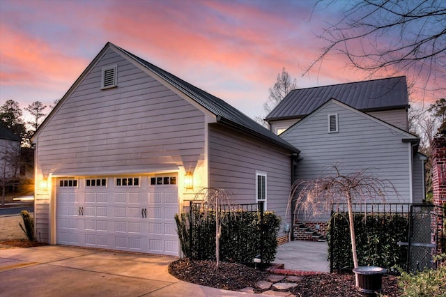 property exterior at dusk featuring a garage