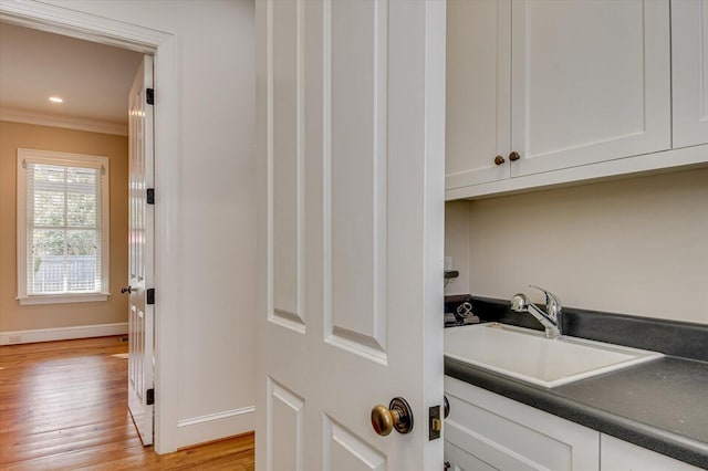 721 Bishops Cir, Evans, GA 30809 - clothes washing area featuring ornamental molding, light hardwood / wood-style floors, and sink