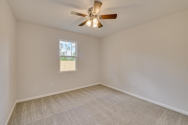 carpeted spare room with baseboards and ceiling fan