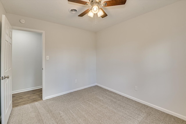 carpeted empty room featuring a ceiling fan, baseboards, and visible vents
