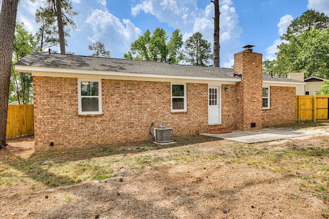 rear view of property featuring a patio, a fenced backyard, a chimney, crawl space, and central air condition unit