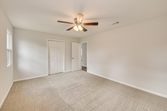 unfurnished bedroom featuring visible vents, carpet, baseboards, and a closet