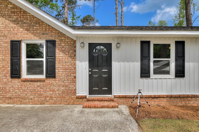 entrance to property featuring brick siding