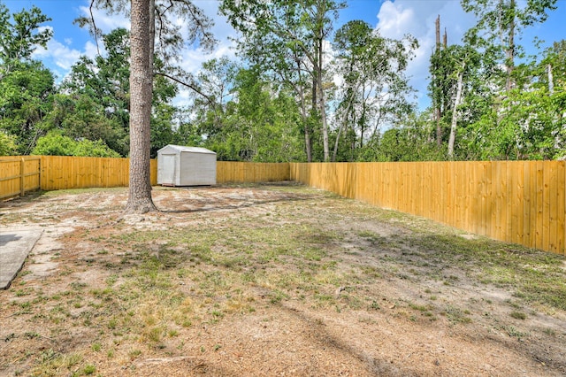 view of yard with a fenced backyard, an outbuilding, and a shed