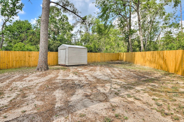 view of yard featuring an outdoor structure, a shed, and a fenced backyard