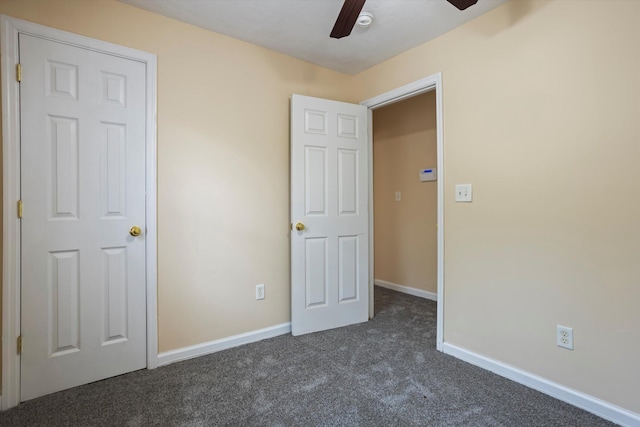 unfurnished bedroom with dark carpet and ceiling fan