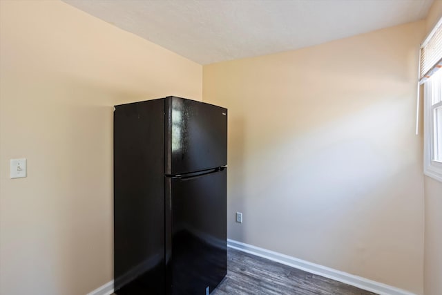 kitchen featuring black refrigerator and dark wood-type flooring