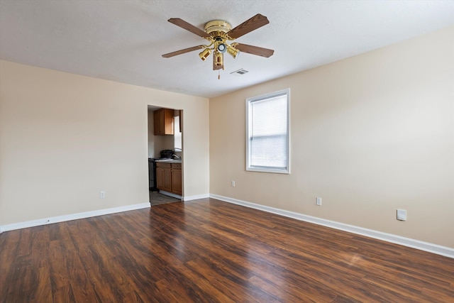 spare room with dark hardwood / wood-style flooring and ceiling fan