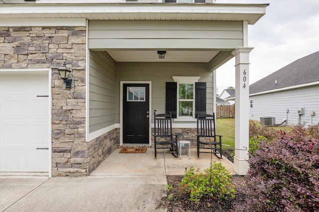 604 Garland Trl, Harlem, GA 30814 - property entrance with central AC, fence, stone siding, and covered porch