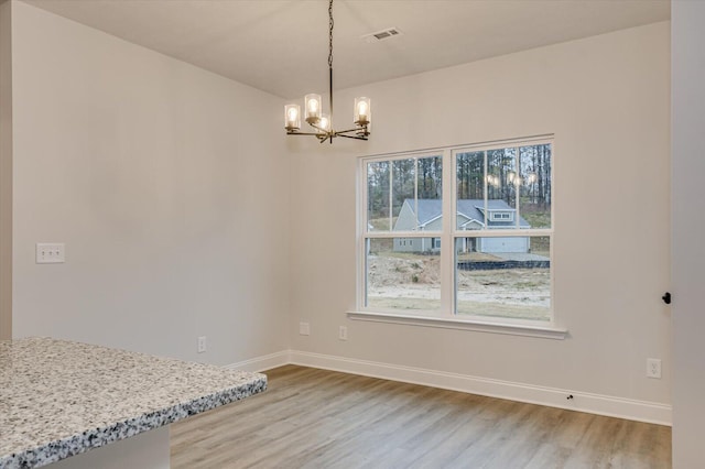 dining space featuring hardwood / wood-style flooring and a notable chandelier