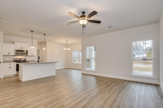 unfurnished living room with ceiling fan with notable chandelier, light hardwood / wood-style flooring, and sink