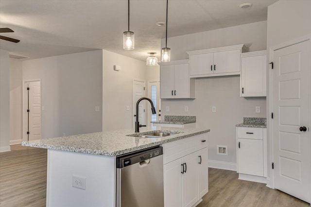 kitchen with dishwasher, sink, light stone countertops, an island with sink, and white cabinetry