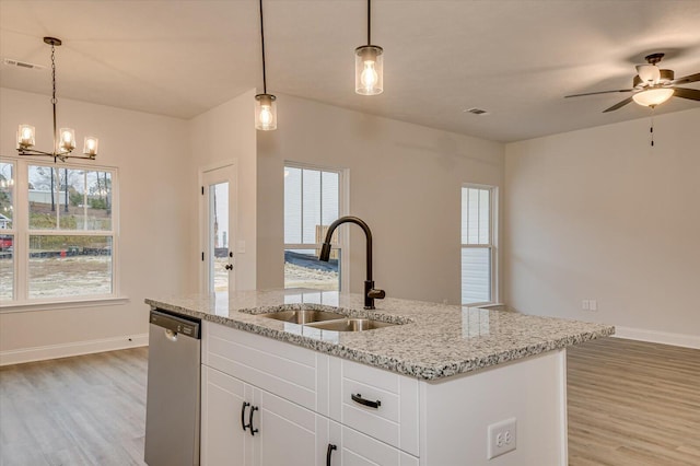 kitchen with dishwasher, white cabinetry, hanging light fixtures, and sink