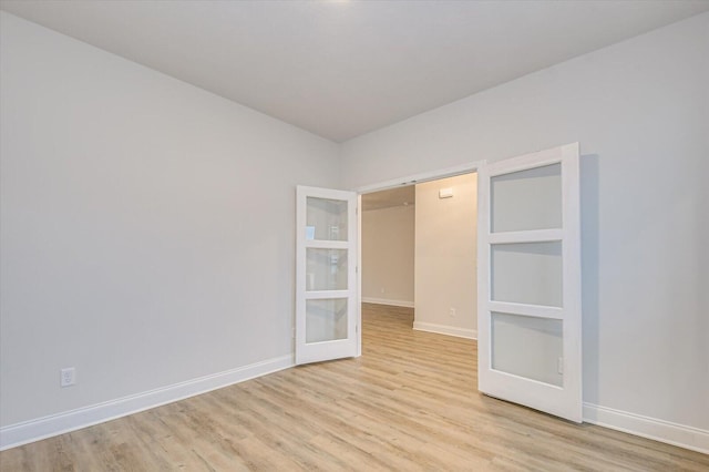 unfurnished bedroom with french doors and light hardwood / wood-style flooring