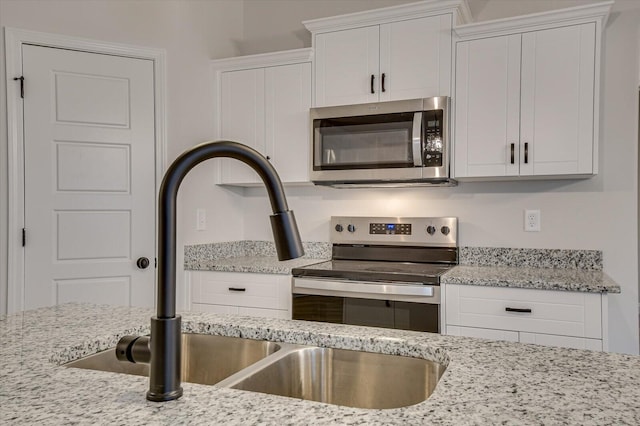 kitchen featuring light stone countertops, sink, white cabinetry, and stainless steel appliances