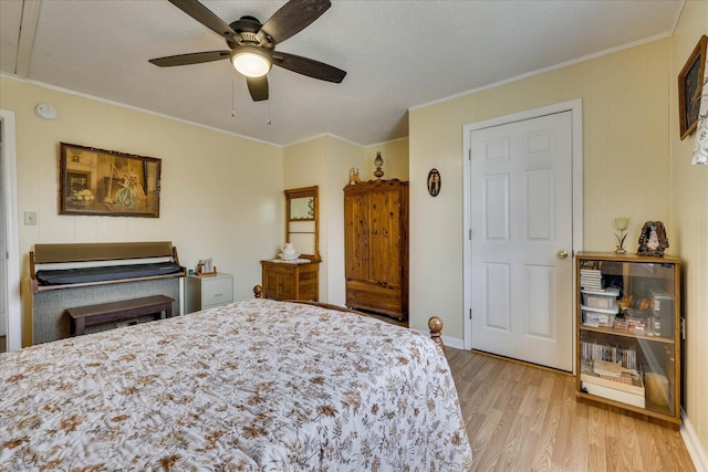 bedroom with a textured ceiling, ornamental molding, wood finished floors, and a ceiling fan