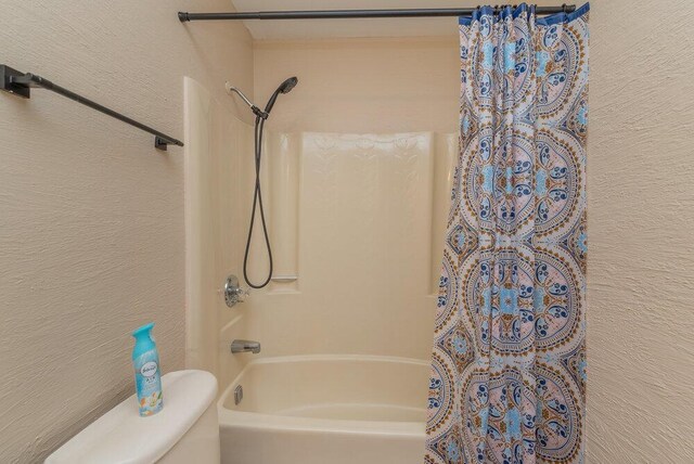 bathroom featuring shower / bath combo and toilet