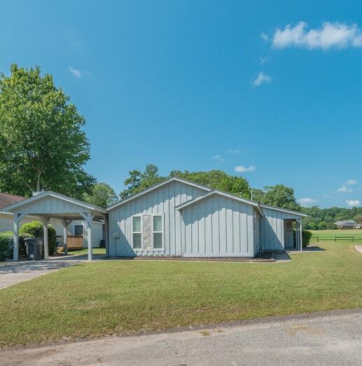 view of side of property featuring a lawn and a carport