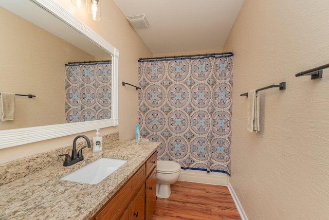 full bathroom with hardwood / wood-style flooring, vanity, toilet, and shower / bath combo with shower curtain