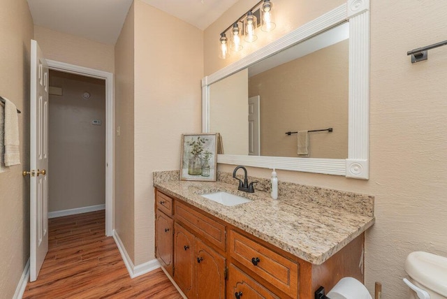 bathroom featuring hardwood / wood-style floors, vanity, and toilet