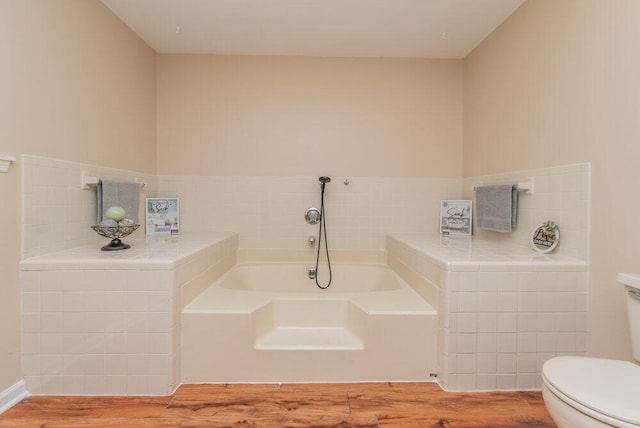 bathroom with a washtub, wood-type flooring, and toilet