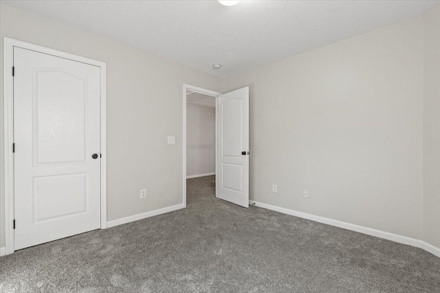 unfurnished bedroom with dark colored carpet