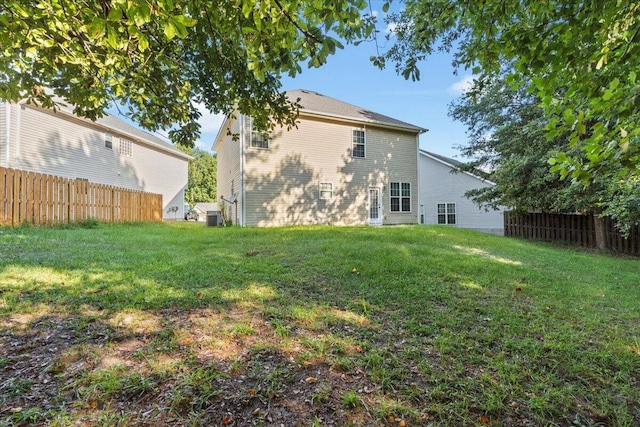 back of property featuring cooling unit and a lawn