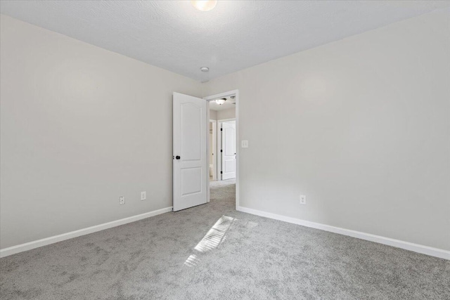 unfurnished room featuring a textured ceiling and carpet floors