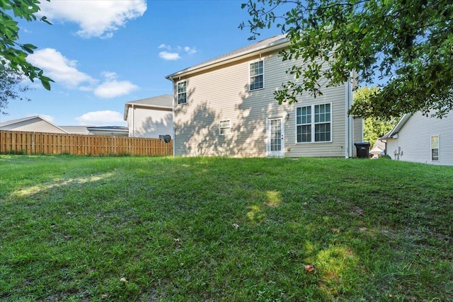 rear view of property featuring a lawn