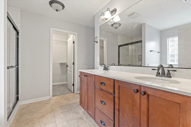 bathroom with tile patterned flooring, vanity, and an enclosed shower