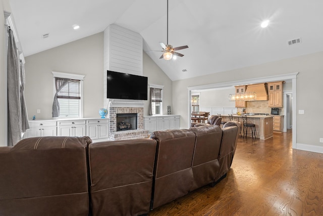 910 Ellis Ln, Evans, GA 30809 - living room with ceiling fan, high vaulted ceiling, a fireplace, dark wood-style flooring, and a chandelier