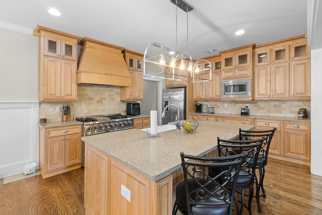 910 Ellis Ln, Evans, GA 30809 - kitchen featuring custom exhaust hood, stainless steel appliances, a sink, wood finished floors, and a kitchen island with sink