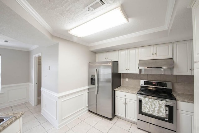 5105 Windmill Pl, Evans, GA 30809 - kitchen featuring appliances with stainless steel finishes, under cabinet range hood, white cabinetry, crown molding, and a wainscoted wall