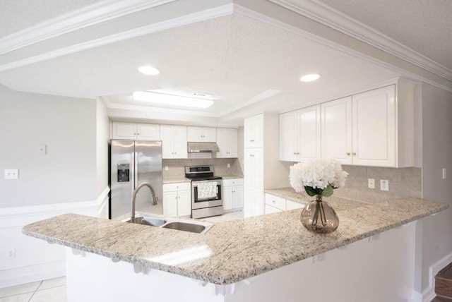 5105 Windmill Pl, Evans, GA 30809 - kitchen with appliances with stainless steel finishes, under cabinet range hood, a sink, a breakfast bar area, and a peninsula